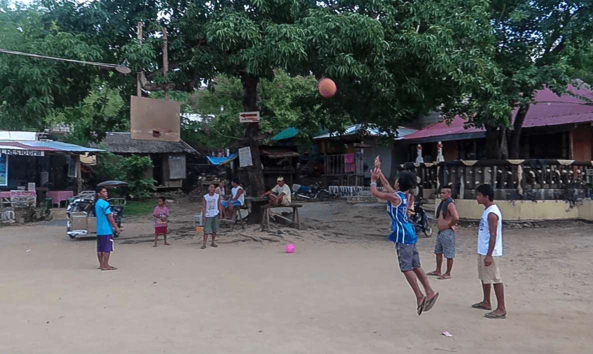 filipino youth playing basketball at a barangay in bolinao pangasinan patar beach philippines